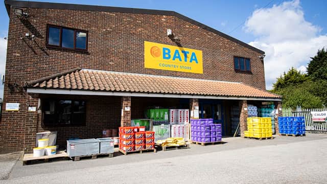 BATA Country Store with colorful crates and containers outside, set against a brick building under a blue sky.