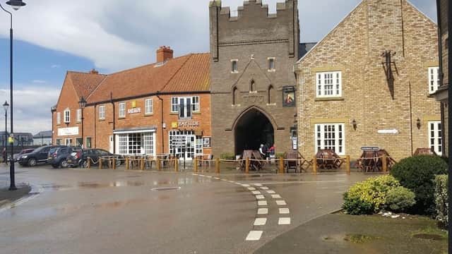 Moonshine Cottage with outdoor seating, brick buildings, and a cloudy sky in The Bay, Filey, Yorkshire.