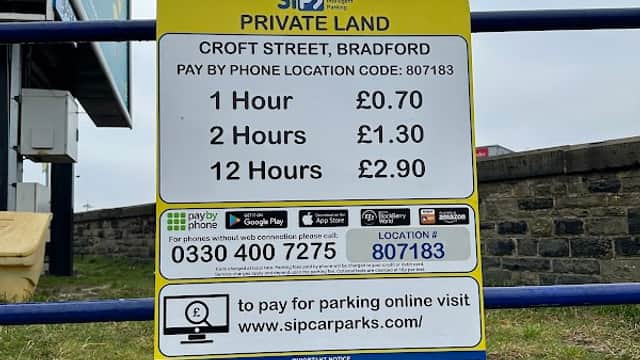Sign for Vicar Lane Car Park detailing parking rates: 1 hour £0.70, 2 hours £1.30, 12 hours £2.30, located in Bradford.