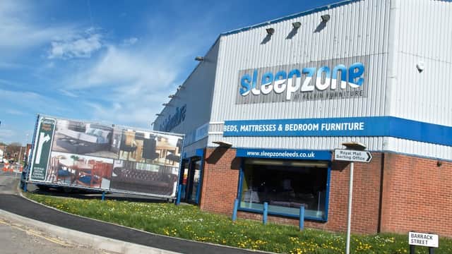 Exterior of Kelvin Furniture shop with a large advertisement showcasing furniture, located on a sunny street in Leeds.