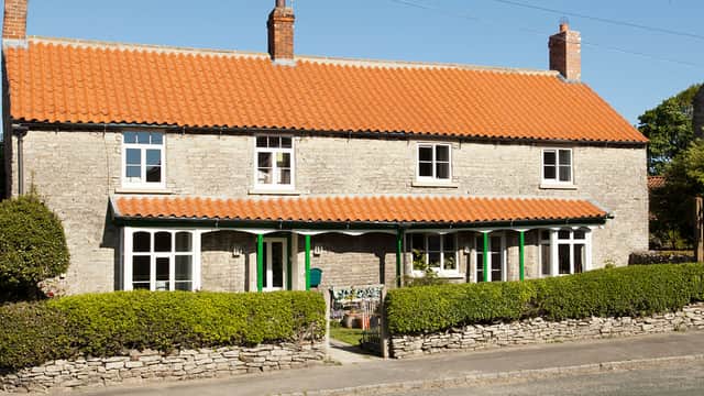 Charming stone building with a red-tiled roof, green accents, and a well-maintained garden in Wrelton, Yorkshire.