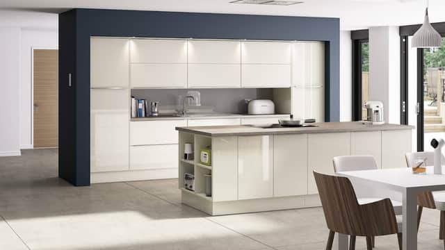 Modern kitchen showroom featuring sleek cabinetry, an island, and contemporary dining area with wooden chairs.