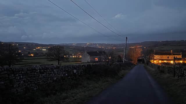 Darley Memorial Hall illuminated at dusk, surrounded by rural landscape and stone walls in North Yorkshire.
