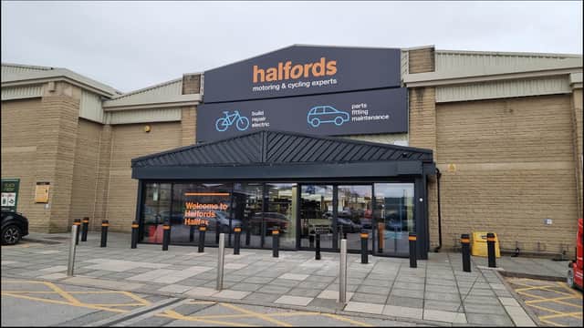 Entrance to Halfords store in Halifax, featuring signage for cycling and automotive services, with a modern facade.