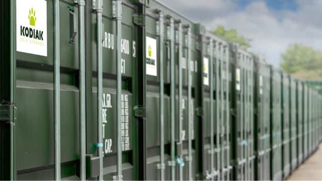 Green storage containers lined up with "KODIAK SELF STORAGE" signage in Sowerby, North Yorkshire under a cloudy sky.