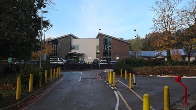 Rotherham Hospital staff car park entrance with pay & display, yellow bollards, and autumn trees in the background.