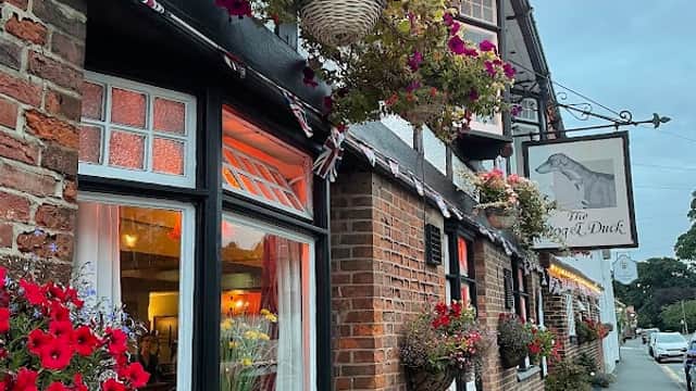 Charming pub exterior with flower baskets, warm lighting, and traditional architecture in Walkington, Yorkshire.