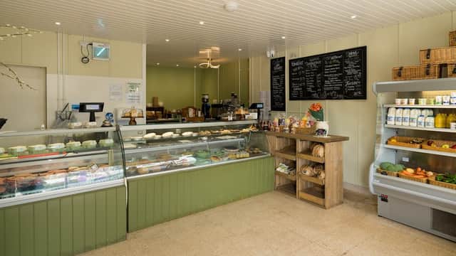Interior of Gilberts Deli featuring display cases, wooden shelves, a chalkboard menu, and a variety of food products.