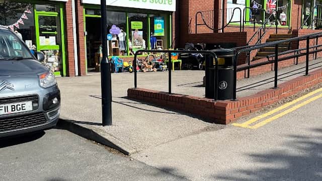 Barnardo's Children's Store with green signage, toys outside, and a ramp, set in a sunny Yorkshire street.