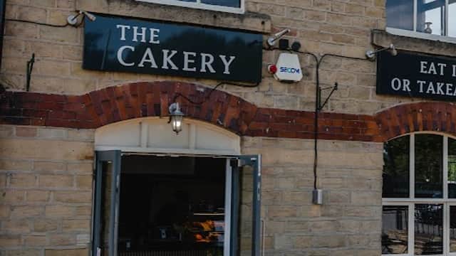The Cakery restaurant entrance featuring stone walls, large windows, and outdoor seating in West Vale, Yorkshire.