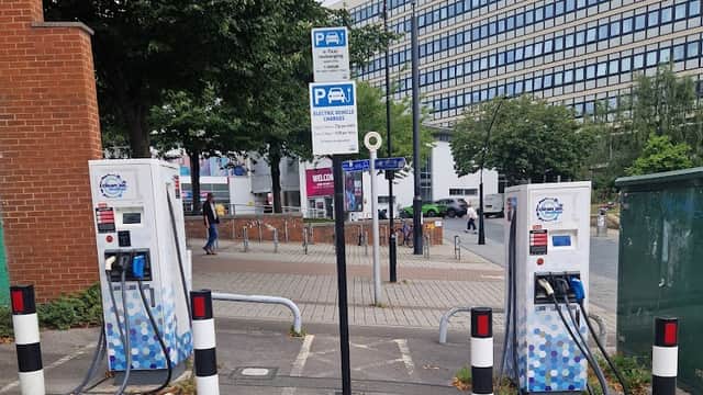 Pay & Display parking area with electric vehicle charging stations, signage, and surrounding greenery in Sheffield.