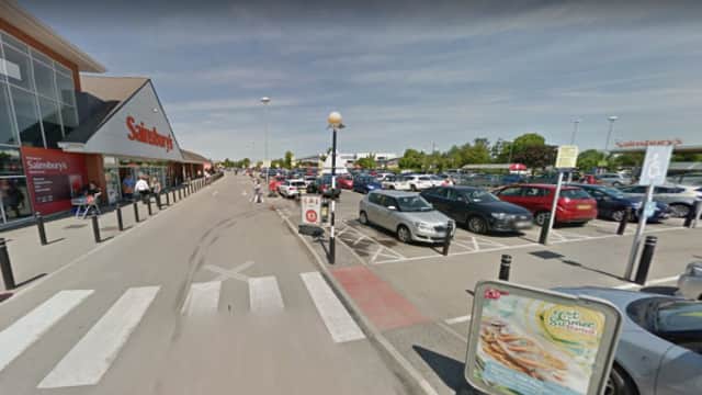 Pay & Display parking area outside Sainsbury's in Earswick, with cars parked and signage visible under clear skies.