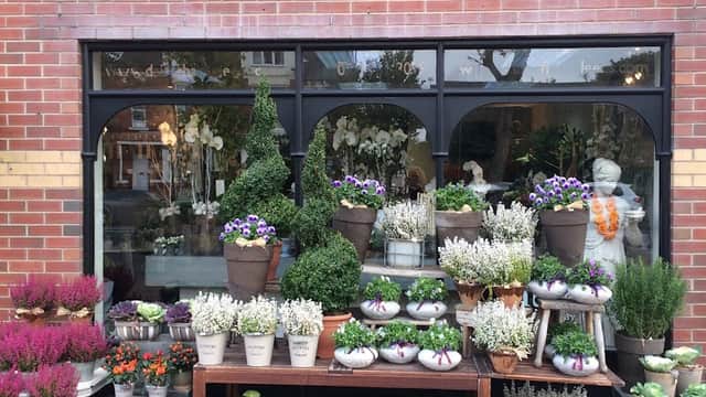 Colorful flower arrangements and potted plants displayed outside Daisy Chain florist in Leeds, Yorkshire.