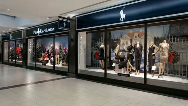 Polo Ralph Lauren Outlet with festive window displays featuring mannequins in stylish clothing and holiday decorations.