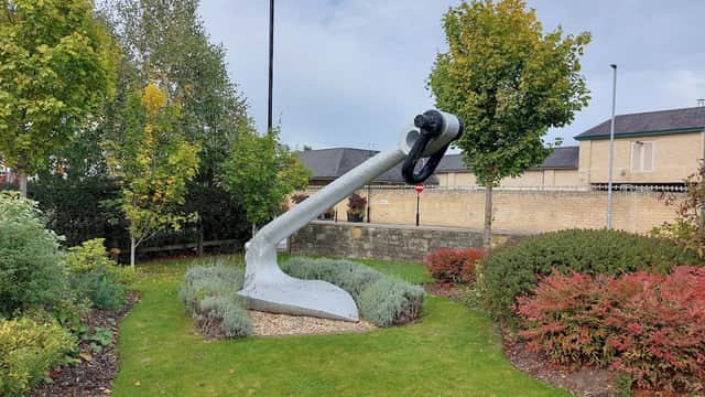 Large anchor sculpture surrounded by greenery and shrubs in a landscaped area near Car Parks in Wetherby, Yorkshire.