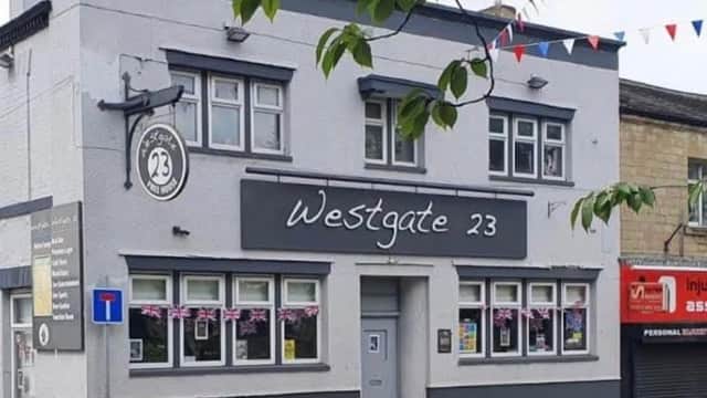 Westgate 23 bar in Liversedge, featuring a gray exterior, large windows, and festive bunting.