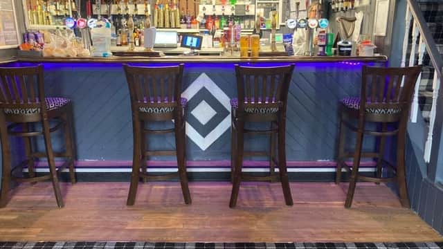 Bar area with high wooden stools, colorful beer taps, and a patterned floor in Lonsdale Hotel, Liversedge.