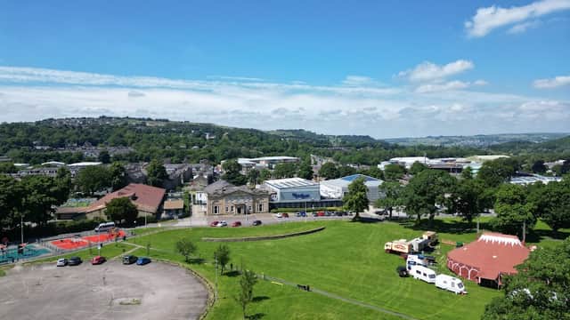 Aerial view of Victoria Park featuring green fields, a building, and a red circus tent under a clear blue sky.