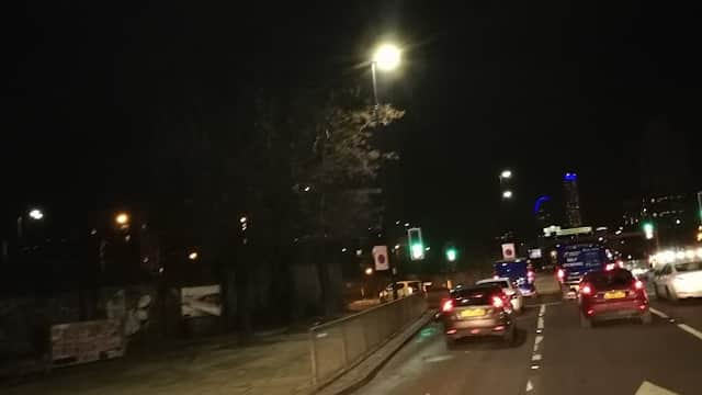 Chappell Drive West Car Park at night, with cars driving and streetlights illuminating the area.