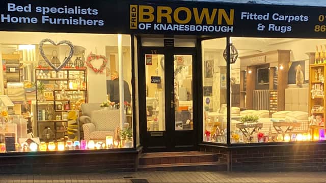 Homeware store with a welcoming display, showcasing beds, carpets, and decorative items, illuminated by soft lighting.