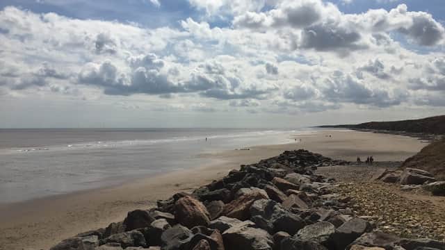 Scenic beach view with rocky shoreline, gentle waves, and cloudy sky in Great Hatfield, Yorkshire.