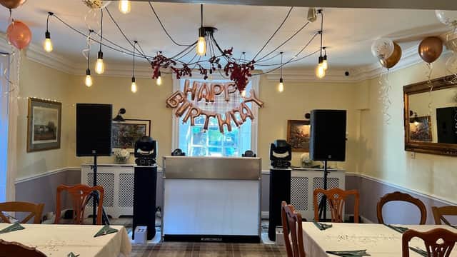 Interior of The Coachman Inn with tables set, a "Happy Birthday" sign, and festive decorations.