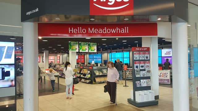 Argos store entrance with "Hello Meadowhall" sign, displays of homeware and electronics, and customers browsing.