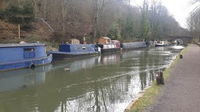 Pay & Display car park near a canal lined with narrowboats and trees in Chiserley, Yorkshire.