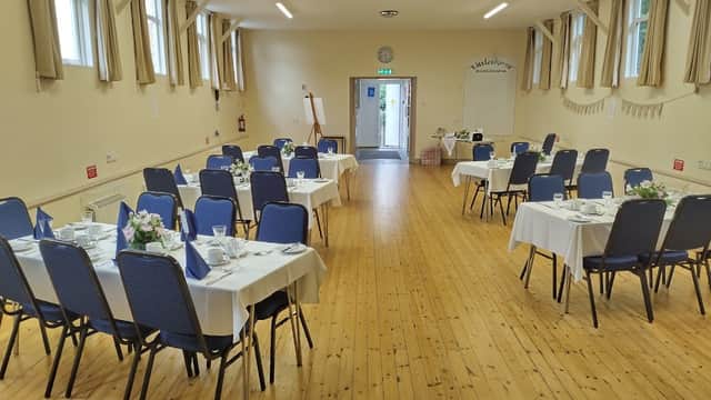 Interior of Littlethorpe Village Hall with neatly arranged tables, chairs, and floral centerpieces, ready for an event.
