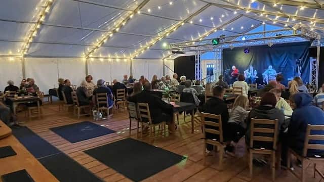 A lively indoor event at The Pearl and Oyster, featuring guests seated at tables under fairy lights.