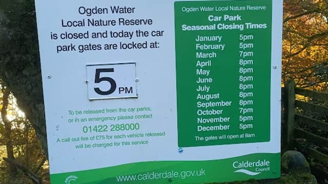 Sign detailing car park hours and important notices at Ogden Water Local Nature Reserve, Mixenden, Yorkshire.