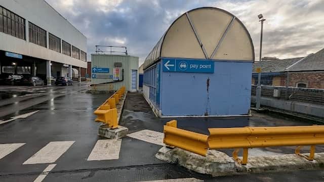 Multi-storey car park with a pay point, yellow barriers, and cloudy sky in Middlesbrough, Yorkshire.