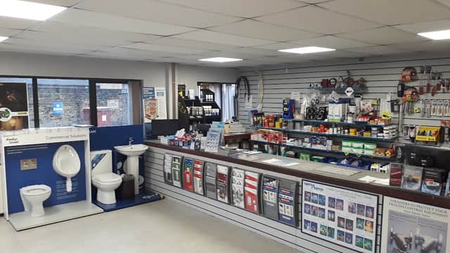 Interior of Crossling Brighouse showing shelves stocked with tools, plumbing supplies, and a display of toilets.