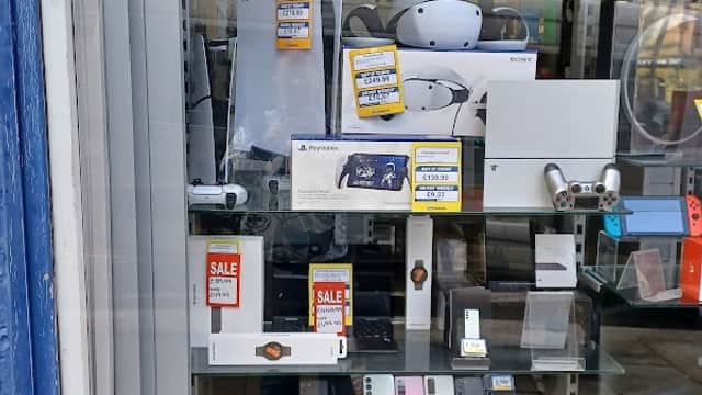 Display window featuring various tech gadgets, electronics, and sale items at Cash Generator Halifax.