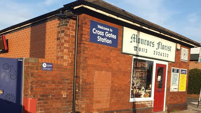 Brick building with a sign reading "Monroes Florist" and a nearby "Welcome to Cross Gates Station" sign.