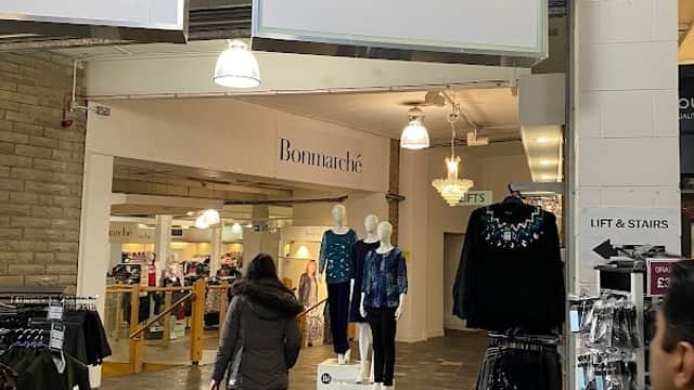 Entrance to Bonmarché with clothing displays and shoppers in a well-lit retail space at Batley Mill.