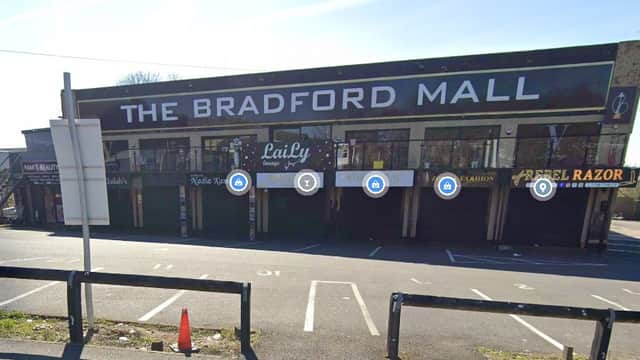 The Bradford Mall exterior with closed shops, parking spaces, and a sign for Pay & Display parking.