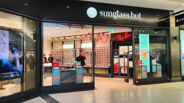 Sunglass Hut storefront featuring a variety of sunglasses and a promotional display inside a shopping center.