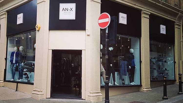 Clothes shop "AN-X" in Bradford with large windows displaying mannequins and apparel, featuring a no entry sign outside.