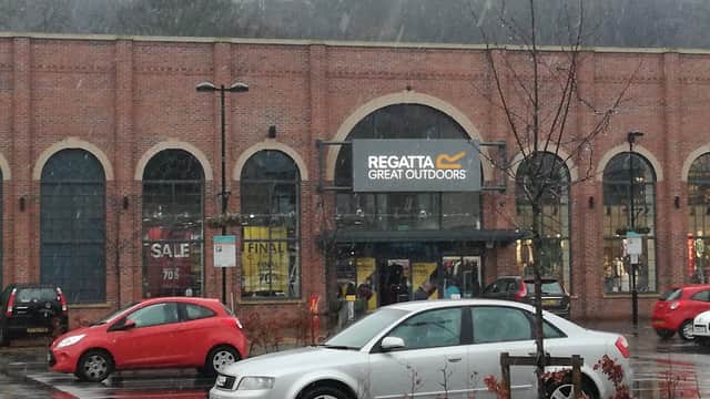 Regatta Great Outdoors store entrance at Fox Valley Market, with cars parked and light snow falling.