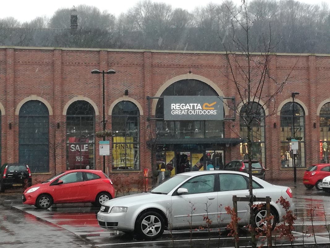 Regatta Great Outdoors store entrance at Fox Valley Market, with cars parked and light snow falling.