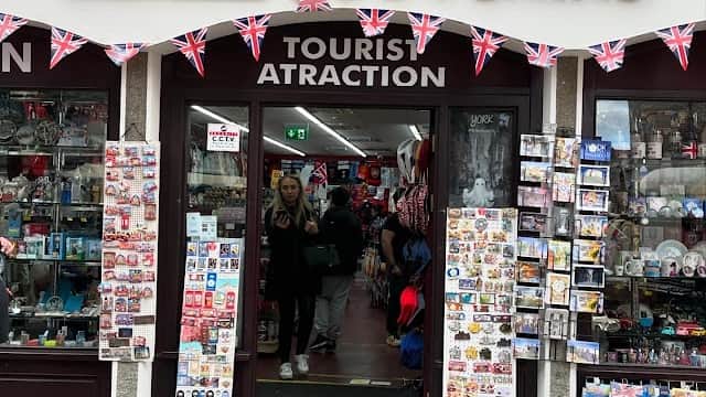 Quaint storefront with "Sterling Souvenirs" sign, British flags, and various souvenirs displayed in windows.