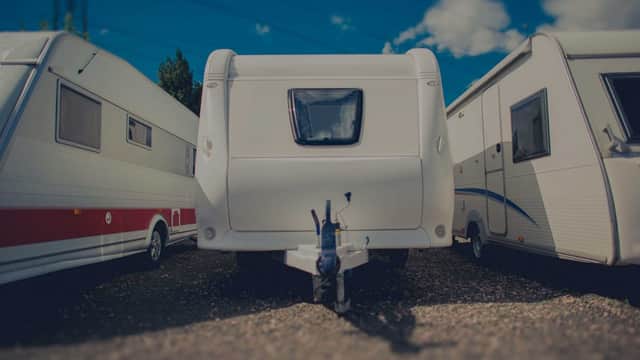 Caravans parked closely together at Teesside Caravan Storage Ltd under a blue sky with scattered clouds.