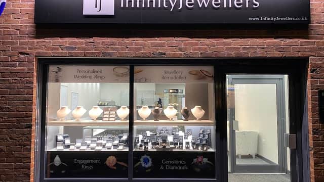 Shopfront of Infinity Jewellers displaying jewelry, including rings and gemstones, with a modern, inviting design.
