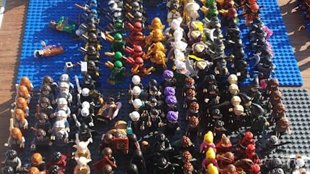 Colorful assortment of miniature figures arranged in rows on a blue surface at a market.