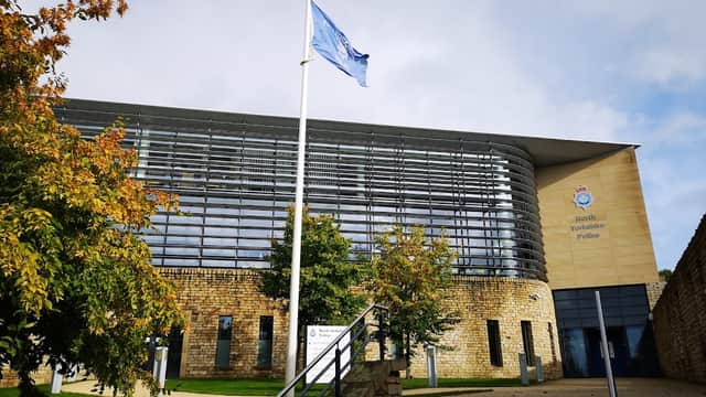 North Yorkshire Police building in Harrogate, featuring a flag, modern architecture, and landscaped surroundings.