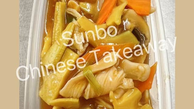 A plastic container filled with chicken and mixed vegetables in a savory sauce.