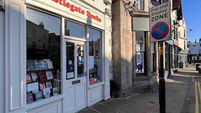 Castlegate Books storefront with books displayed, beside a street sign indicating a pay and display zone.