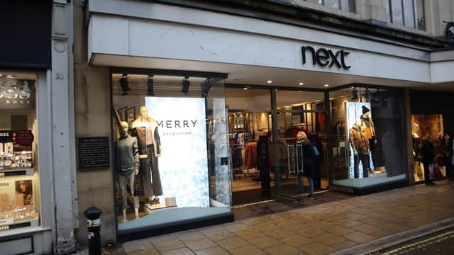 Next store front in North Yorkshire, featuring mannequins in festive attire and large promotional displays.