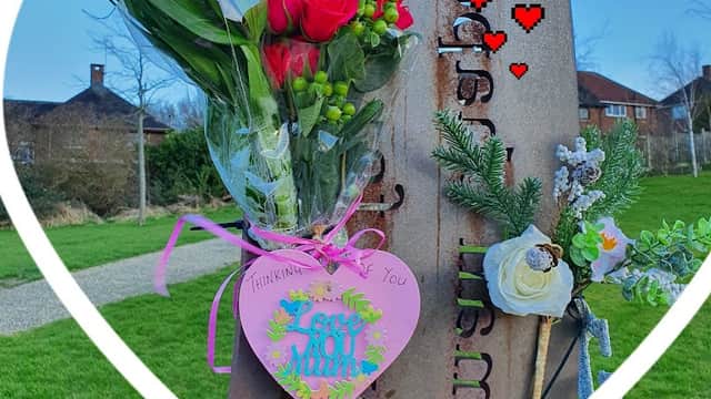 A heart-shaped frame surrounds a bouquet and a decorative heart tag at Castle View Park, with greenery and blue sky in the background.